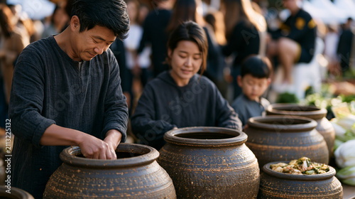Korean family fills onggi earthenware jars with kimchi in crowded public market square, pool lifeguard on duty watches from elevated chair at nearby community event, before and