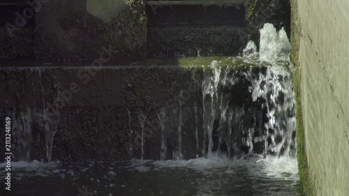 Water leaking through wooden canal lock gate in Birmingham.
Close-up shot of water splashing and leaking through a mossy lock gate on the Grand Union Canal in Birmingham, UK.