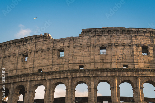 Colosseum, a UNESCO World Heritage site, showcases ancient Roman architecture with its iconic weathered stone facade and arches under a clear blue sky, symbolizing enduring historical legacy