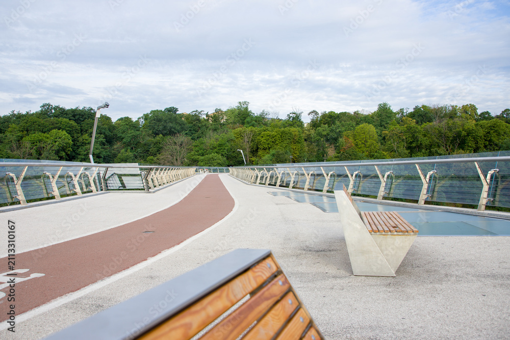 Fototapeta premium Pedestrian bridge. Bicycle lane in the city park. 