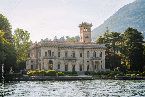 Villa Erba, a historic villa with elegant architecture, surrounded by lush greenery and mountains near a tranquil lake