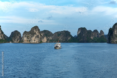 Bild auf Leinwand A panoramic view showcases several cruise boats sailing gracefully around the towering limestone karsts of Ha Long Bay, Vietnam, highlighting its natural grandeur and iconic seascape