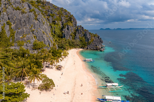 Obraz na płótnie Aerial view of Black island in the Philippines with beautiful sand beach, stranded shipwreck and moared boats