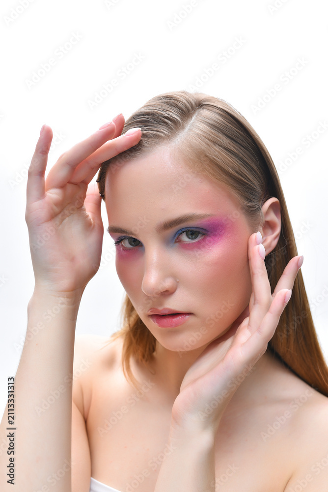 Fototapeta premium A beautiful girl with long blonde hair in profile. Pink and purple blush on her cheeks. Blue and purple eyeshadow on her eyelids.