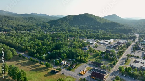 Aerial view of Court Street in Elizabethtown, New York, surrounded by forested Adirondack mountains under clear summer skies.