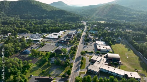 Aerial view of Court Street in Elizabethtown, New York, surrounded by forested Adirondack mountains under clear summer skies.
