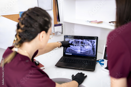 Dentists reviewing dental x-ray in modern clinic