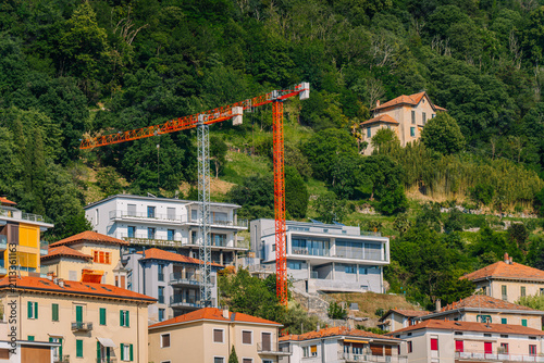 Принти на полотні Construction crane overlooking residential buildings on hillside in Como, Lombar