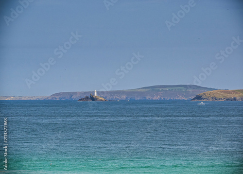 Foto A lighthouse set against a distant a headland in the hazy background