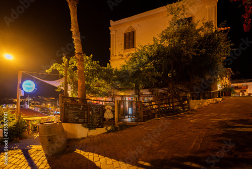 Quadro su tela Charming outdoor cafe and historic building on cobblestone street at night in Ka