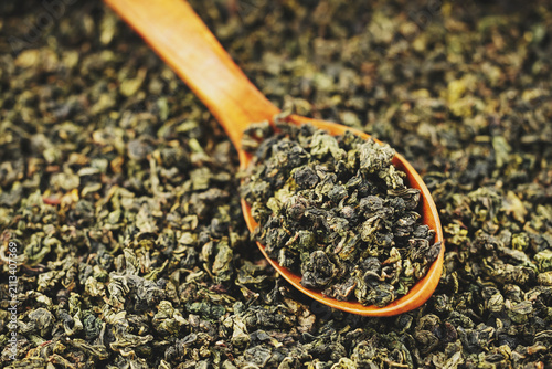 Premium dried oolong tea scoop on minimal solid background