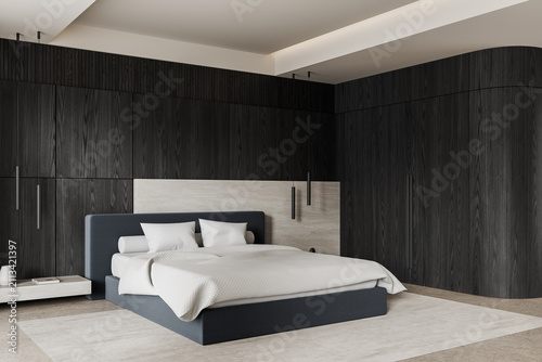 Fotografía Contemporary minimalist bedroom interior with dark wood wall panels, soft bedding, pendant lights, and elegant architectural lines