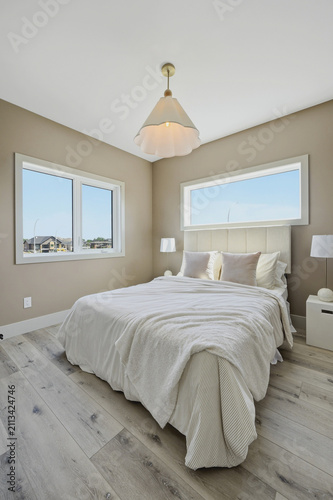 Coastal-inspired bedroom features a plush bed and ample natural light