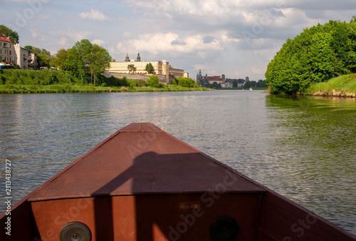 Obraz na plátne Scenic perspective from the bow of a wooden sightseeing boat approaching Wawel Royal Castle along the Vistula River in Krakow, Poland