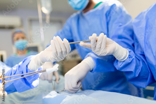 Fotografija Surgical Team Passing Instruments During Operation in Modern Operating Room
