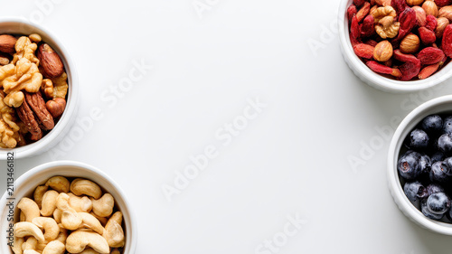 Assorted nut bowl snack blueberry fresh healthy food white background minimal style top view copy space clean layout organic ingredient superfood mix simple design nutritious snack with assorted