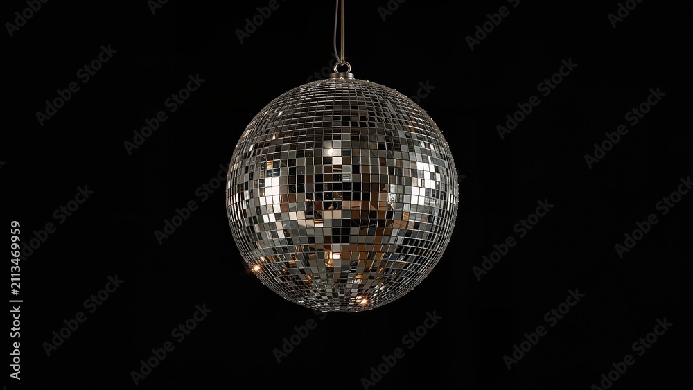 Obraz premium Disco ball hanging in the dark with reflective mirrored surface and light reflections. Party decoration and entertainment element. The concept of lighting and celebration.