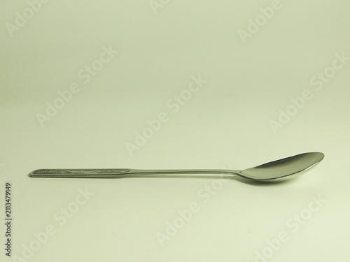 Stainless steel metallic long handle dessert spoon isolated on white background