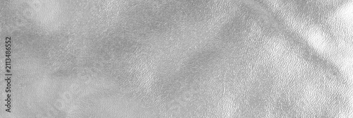 Silver metallic leather texture background with subtle grain and reflective highlights for design