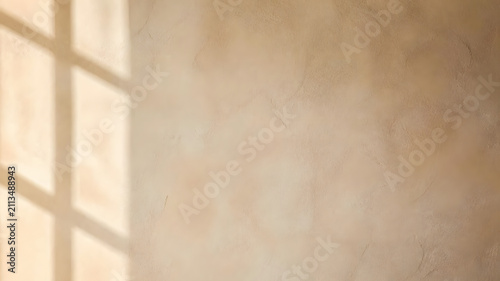 Textured beige wall surface featuring aesthetic window frame shadows cast in warm natural sunlight for a minimalist interior design backdrop