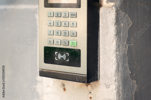 Modern outdoor smart intercom access panel with video camera, PIN keypad, and RFID contactless reader mounted at building entrance.