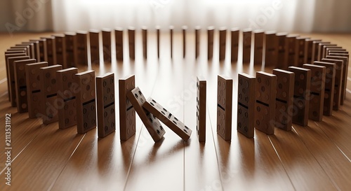 Wooden dominoes standing in a circle with one block falling on table