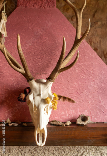 Obraz na płótnie A fireplace decorated with deer skull in a vintage interior.