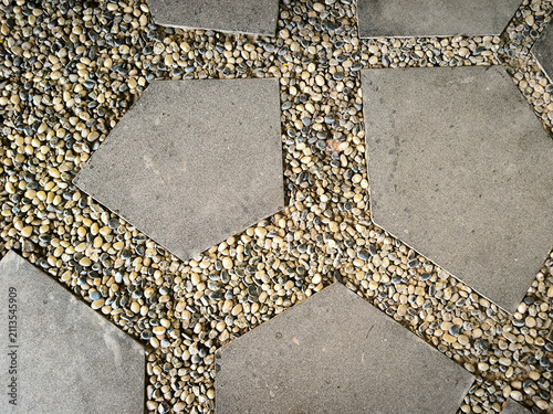 Foto Top down view of pentagonal paving stones surrounded by small pebbles