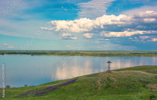 Wooden cross on the high bank of the Volga river