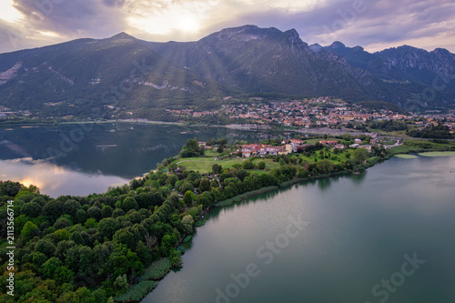 фотографія Calm mountain lake reflecting Alpine peaks and lakeside village at dawn, Brianza