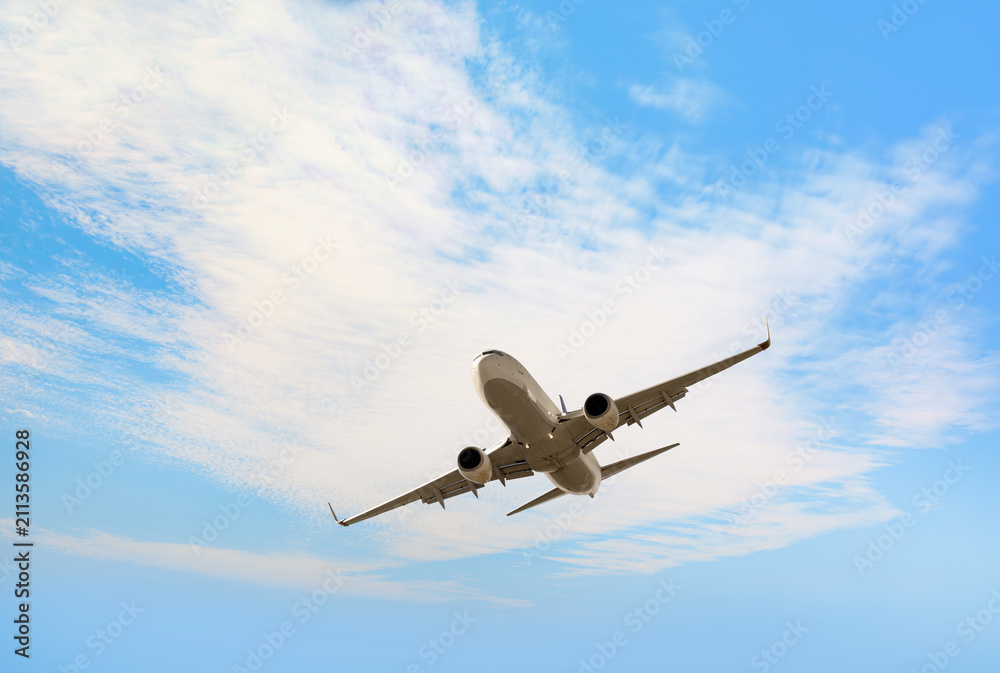 Fototapeta premium White passenger airplane flying in the sky amazing clouds in the background - Travel by air transport