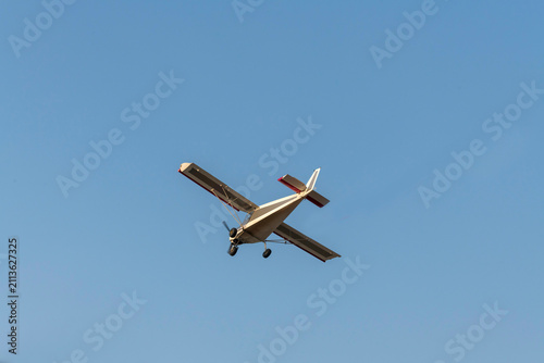 Old classic propeller airplane turning on isolated blue sky