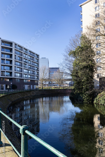 View of the Schelde River and surrounding buildings as it flows through the suburb of Ledeberg in Gent, East Flanders, Belgium.