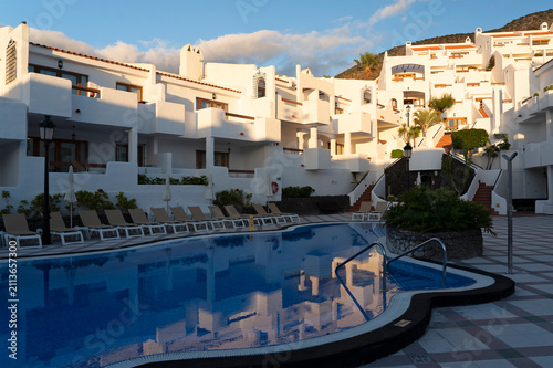 White resort hotel with swimming pool and mountain backdrop, Los Cristianos, Tenerife
