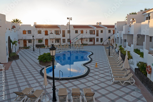 White resort hotel with swimming pool and mountain backdrop, Los Cristianos, Tenerife