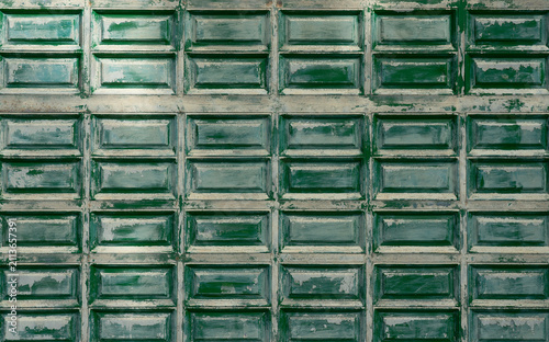 Weathered green wooden door panels with peeling paint texture background