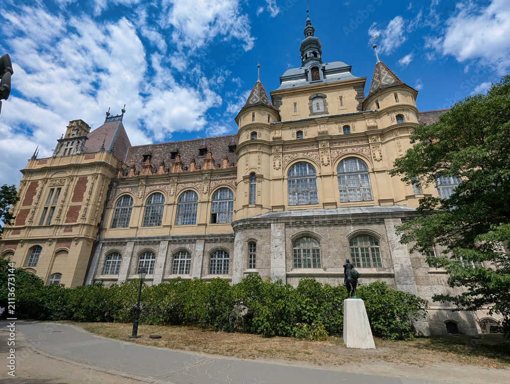 Obraz premium Main façade of Vajdahunyad Castle with towers, decorative stonework and historic architecture in City Park, Budapest, Hungary.
