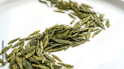 Dried green tea leaves arranged in wavy line on bright white surface macro shot of organic tea foliage.