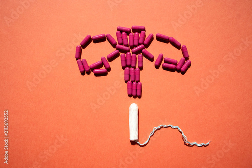 Fotografía Artistic arrangement of purple capsules and a white tampon forming a uterus shap