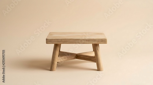 Minimalist wooden stool with square top and cross legs, simple design, isolated on soft beige background.
