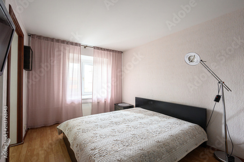 Cuadro en lienzo bedroom features a double bed with a textured beige bedspread and a dark headboa