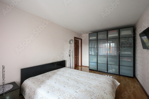 Fotografía bedroom features a double bed with a patterned bedspread and a sleek black headb
