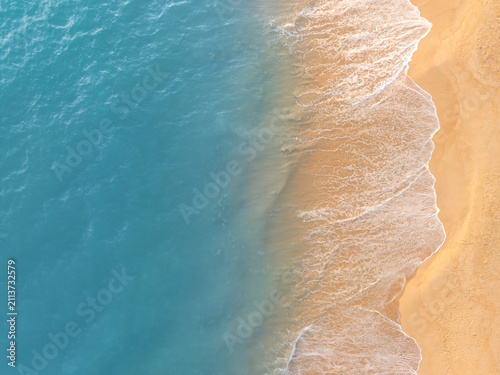 Cuadro en lienzo Aerial view of ocean waves gently touching sandy beach shoreline creating a calm coastal pattern