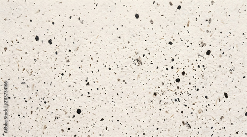 Close up macro shot of white handmade recycled paper texture with scattered black ink speckles and natural fiber grain details