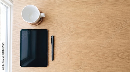 Minimalist workspace with empty coffee cup tablet pen with pen light wooden table near window clean organized workspace workspace inspiration workspace essentials office organization clean desk