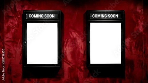 Two empty 'COMING SOON' movie poster frame template mounted side-by-side on a red velvet wall
