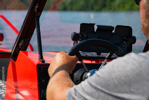Tableau sur toile A man drives a riverboat on a sunny summer day