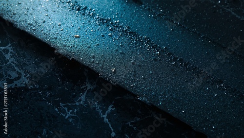 Water Droplets on a Dark Surface in a Dimly Lit Setting During Nighttime