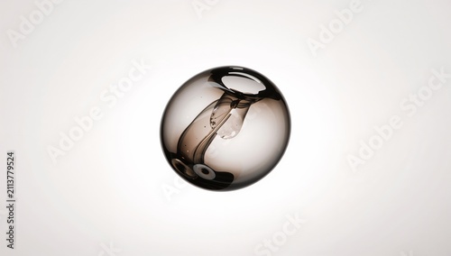 Glass Orb With Liquid Inside Floating Against a Light Background