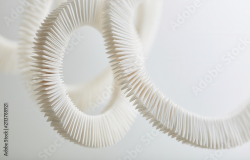 Unique design of curved paper strips hanging in a modern space during daylight